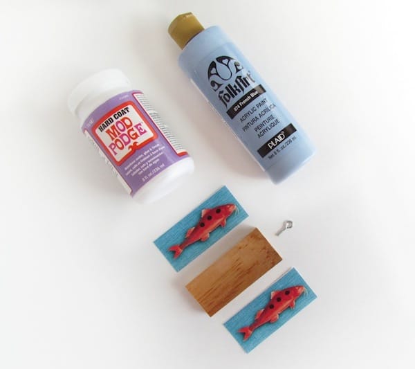 Hard Coat Mod Podge, blue paint, a wood block, two fish images, and an eye hook